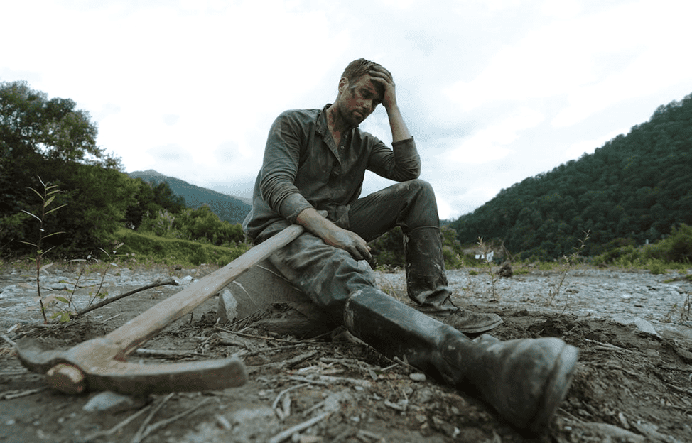 Struggles of Hard Work in Business | eFinancialModels Man sitting exhausted with a pickaxe, symbolizing business challenges.