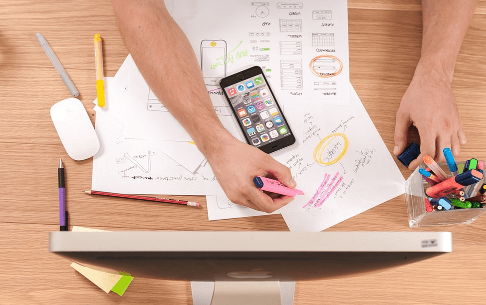 Collaborative Workspace for Financial Planning | eFinancialModels Workspace with notes, smartphone, and highlighters for financial model planning.