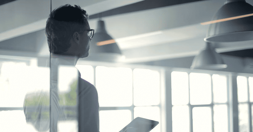 Professional Analysis in a Modern Workspace | eFinancialModels Business professional reflecting while reviewing data on a tablet.
