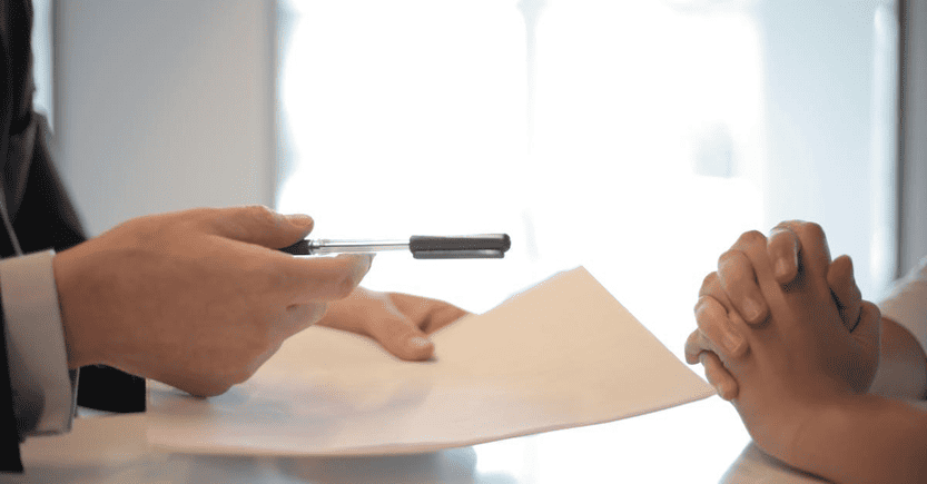 Signing a Financial Agreement | eFinancialModels Hands preparing to sign a document, symbolizing a business agreement.