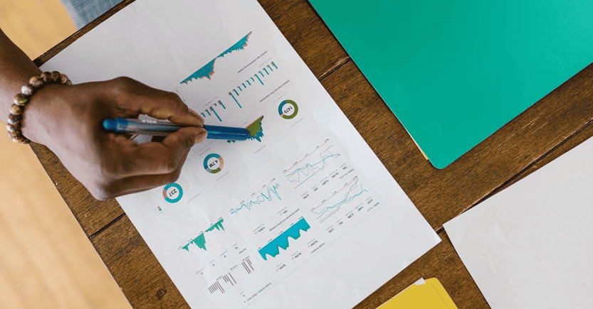 Financial Performance Analysis with Charts and Graphs | eFinancialModels Person reviewing financial graphs and data analysis sheets.